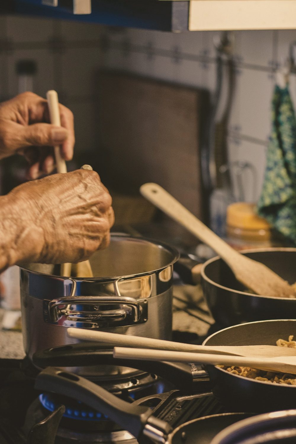 Mãos a mexer o conteúdo de uma panela ao lume